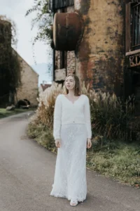 Mariée en robe et maille sous la neige pour un mariage d’hiver chic