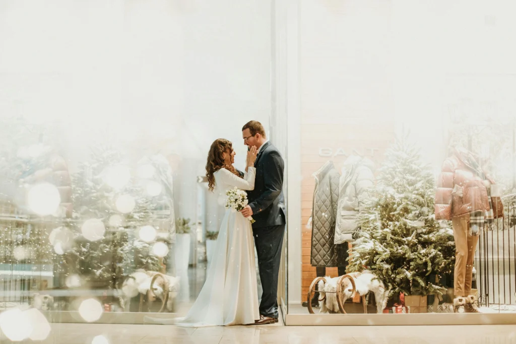 Futurs mariés de dos devant un chalet pour un mariage d’hiver à la montagne