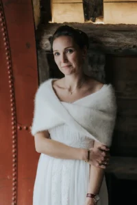 Mariée en robe et maille sous la neige pour un mariage d’hiver chic