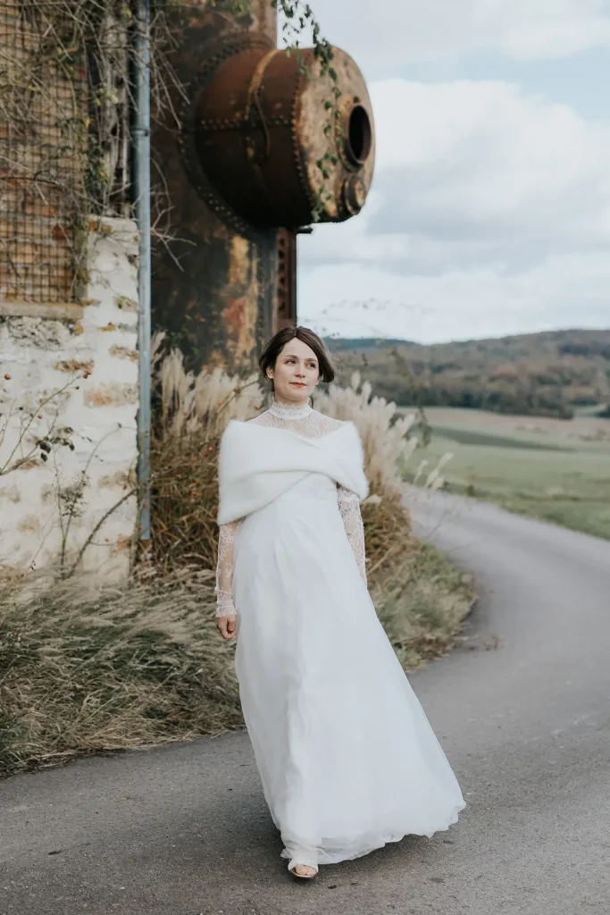 Mariée en robe et maille sous la neige pour un mariage d’hiver chic