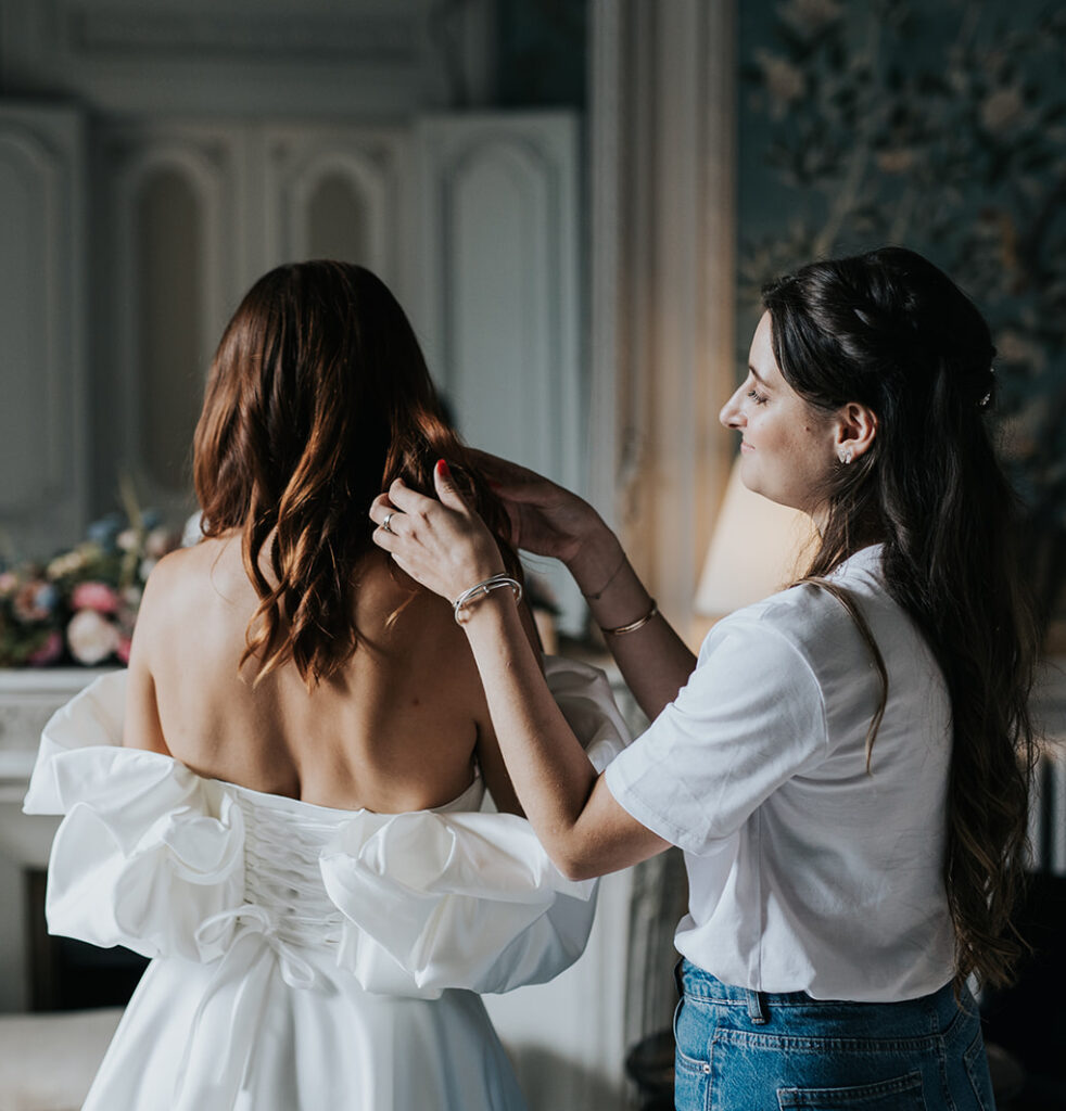 Wedding planner ajustant la coiffure de la mariée le jour du mariage