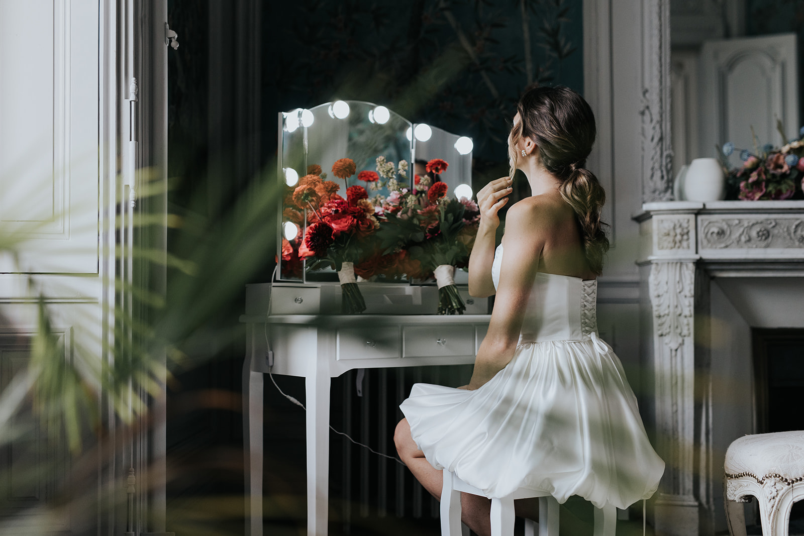 Mariée de dos devant un miroir pendant les préparatifs du jour J. Wedding planner jour J : tout ce que vous ne voyez pas. wedding planner jour J